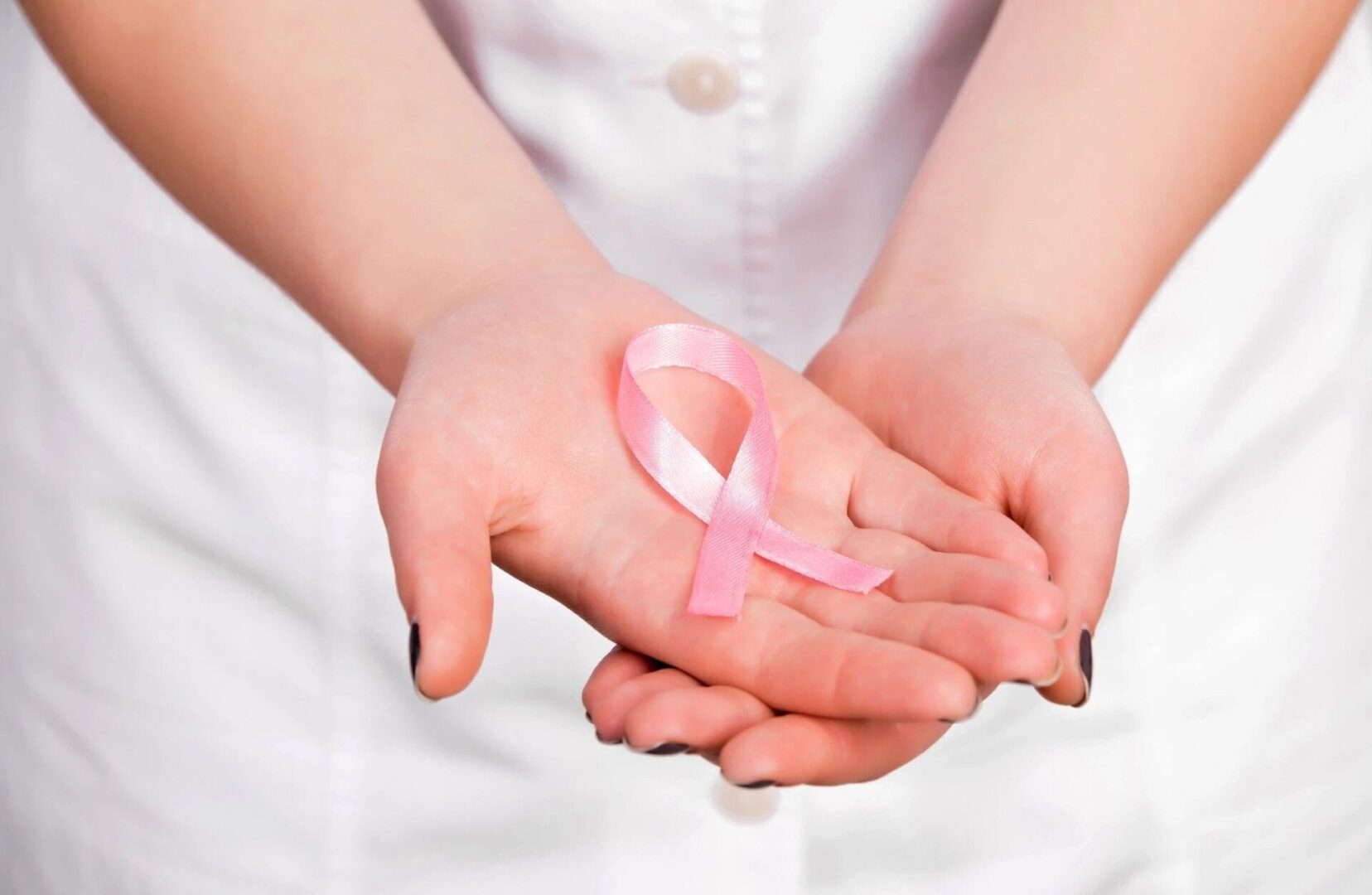 Pink cancer ribbon in hand